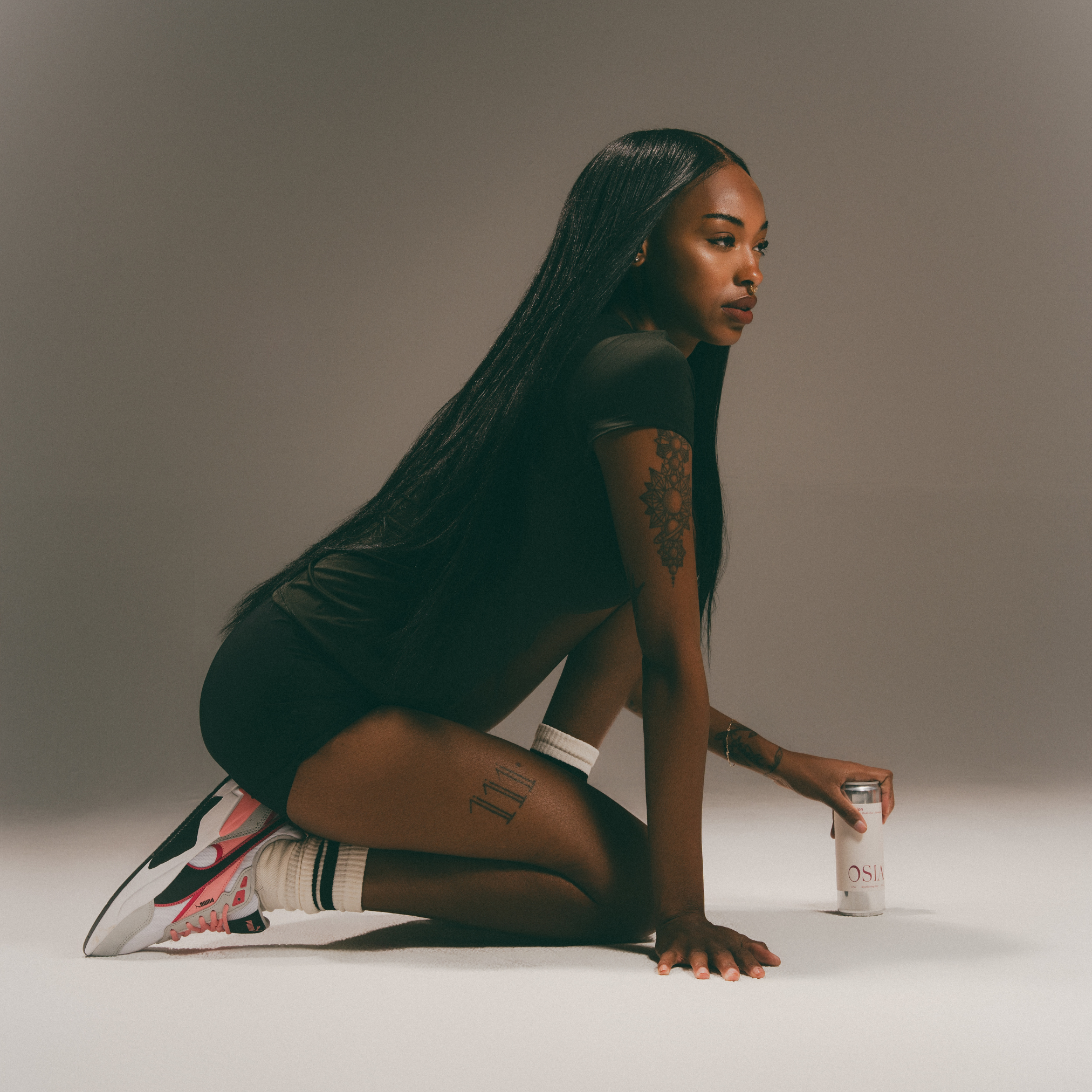 Woman in activewear outfit holding a can of Passion Spritz by OSIA for editorial shoot. 